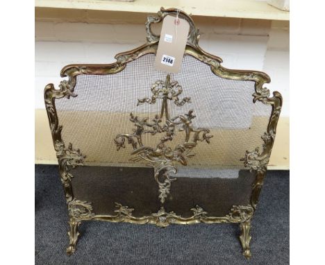 A gilt bronze and wire mesh fire screen of rococo style, early 20th century, with ornate foliate scroll frame centred with tw