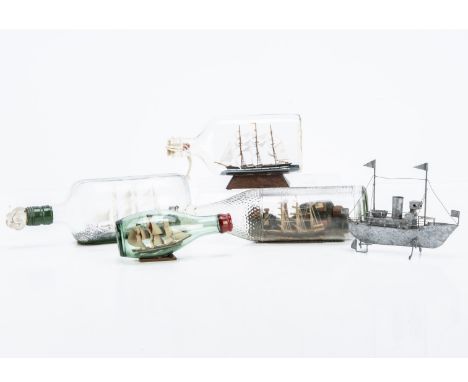 A collection of Ships in Bottles and a tin model ship, four bottles, each with three masted sailing boats and a small souveni