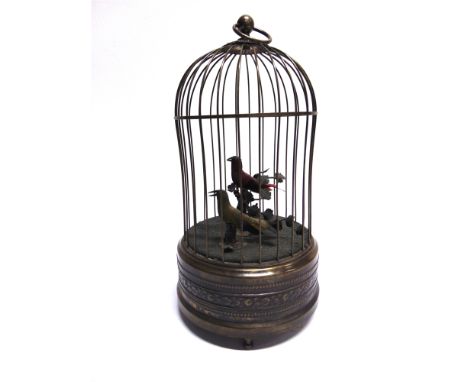 A BIRD AUTOMATON  comprising two song birds in a patinated metal cage, with a clockwork mechanism, overall 27cm high. 