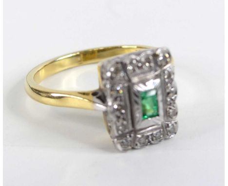 A yellow and white metal, emerald and diamond rectangular cluster ring, featuring a centre step-cut emerald within a border o