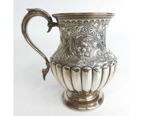 A late Victorian silver tankard, of lower bulbous waisted form, having gadrooned lower body and scroll floral cast upper with