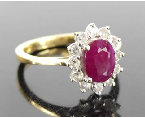 An 18ct yellow and white gold, ruby and diamond oval cluster ring, the centre ruby measuring approx 8 x 6.2 x 3.6mm, weight e