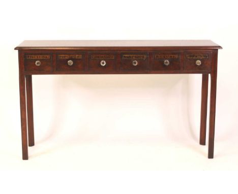 An oak apothecary hall table in the Georgian style, having six annotated frieze drawers with moulded glass knobs, all raised 