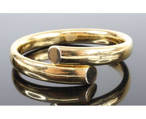 An 18ct yellow gold hinged crossover style oval bangle, width 10mm, diameter 65 x 56mm, gross weight 35.2g, stamped and teste