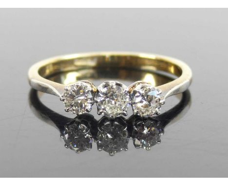 A yellow and white metal diamond three-stone ring, featuring three round brilliant cut diamonds in claw settings, diamond dim