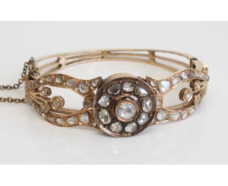 A late Georgian yellow metal rose cut diamond hinged bangle comprising 56 rose cut diamonds arranged as a central circular cl