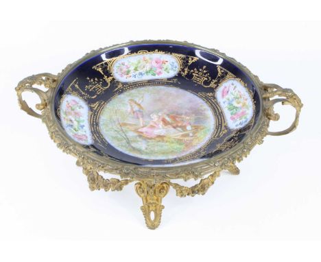 A circa 1900 Sèvres style porcelain table bowl, housed in floral cast twin handled gilt metal mounts, the porcelain decorated