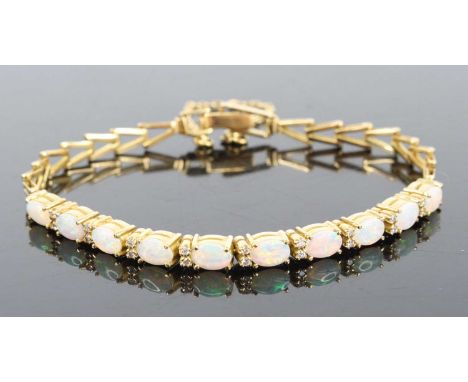 An 18ct yellow gold opal and diamond bracelet, comprising ten oval opal cabochons alternating with nine pairs of round brilli