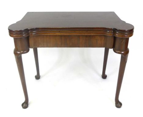 A mid-18th century 'red walnut' triple leaf fold-over card table, having a gamesboard top with four small ivory roundel inset