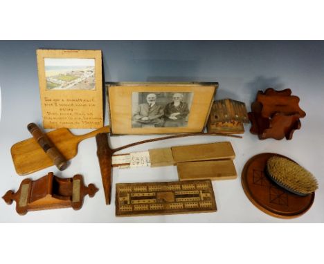 A selection of treen items to include: a cribbage board; a puzzle money box; a rustic pipe; a hand mirror; a wall mounted mat