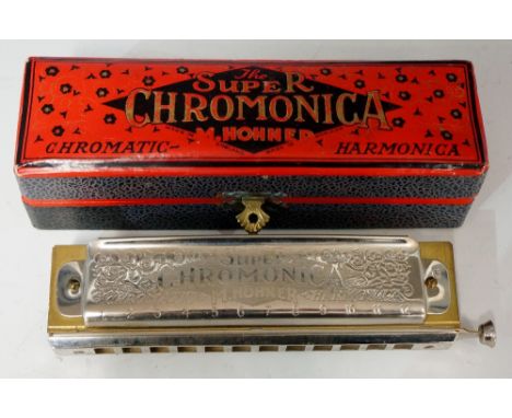 A harmonica, the sides engraved with The Super Chromonica M Hohner, in original box, 15.5cm high, 4cm wide