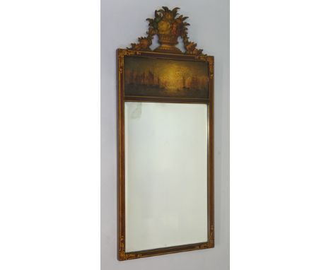 A mahogany framed portrait mirror with fret cut finial of flower basket and swags above a panel painted with a shipping scene