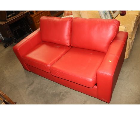 A red upholstered two seater sofa bed