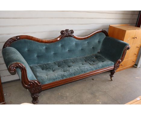 A Victorian carved mahogany button down upholstered settee having scroll ends