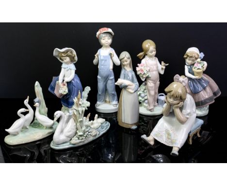 Lladro figures including Boy with accordion six others And one Nao figure of birds.