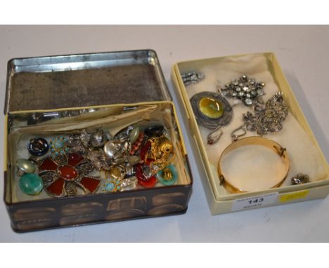 A tin and a tray of various costume brooches, ear-rings, a bangle etc. 