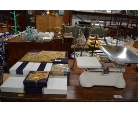 A set of kitchen scales together with a metal book stand and a quantity of place mats and coasters 