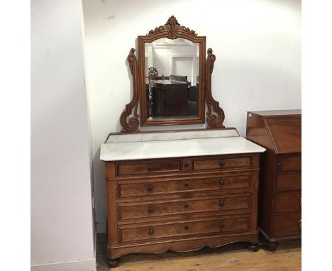 A mid 19thc French walnut and marble topped commode, the moulded top with canted angles above two short and three long fielde