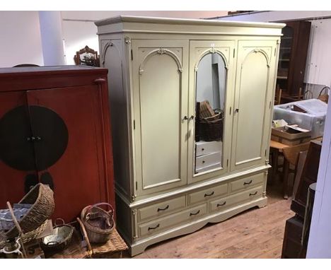 A modern pale green painted mirror door wardrobe, the projecting cornice and plain frieze above a central arched mirror plate