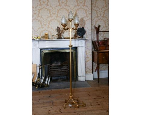 A contemporary gilt brass standard lamp with four scrolling branches and central branch all with opaque glass flambeau shades
