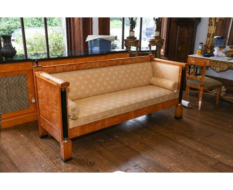 A Biedermeier style satin birch and ebonized sofa, upholstered in patterned fabric, the straight back with turned finials, th