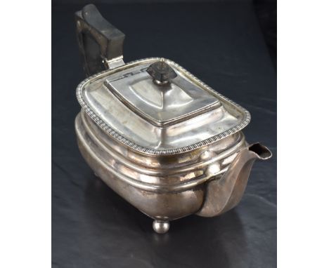 A George V silver teapot, of rounded rectangular form with hined finial topped cover within a moulded rim, angular handle and