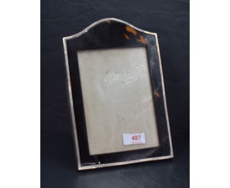 A George V silver and tortoiseshell photograph frame, of arched rectangular form with material covered easel back, marks for 