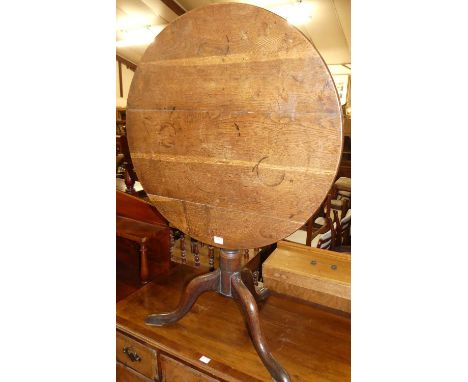 An early 19th century provincial oak and elm circular tilt-top pedestal tripod table, dia. 73cm