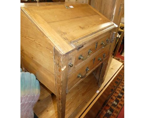 A rustic pine slopefront desk, having a hinged fold-over surface with twin long drawers, width 60cm, together with a further 