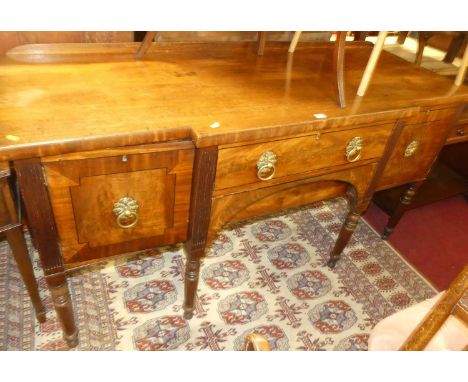 A George IV mahogany, flame mahogany, and ebony strung breakfront sideboard, having single central drawer over blind arched a