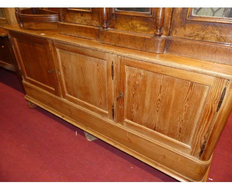 A 19th century Continental rustic stained pine round cornered three door side cupboard, raised on flattened ball supports, wi