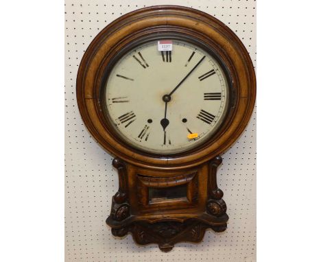 A mid-Victorian carved oak droptrunk wall clock, the white enamel dial with twin winding holes, with small glazed trunk door 