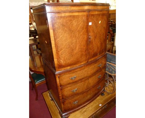 A figured walnut bowfront compactum side cabinet, having twin upper doors over three long drawers to squat cabriole supports,