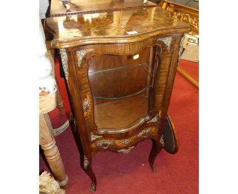 An early 20th century French figured walnut and cross banded serpentine front single door glazed low vitrine, with single lon