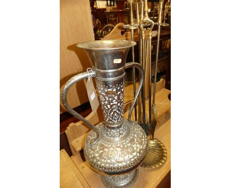 An Eastern embossed metal twin handled bulbous vase, height 65cm, together with a set of brass fire tools on stand (2)