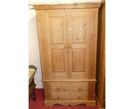 A modern pine double door wardrobe, having twin long lower drawers, w.110cm 