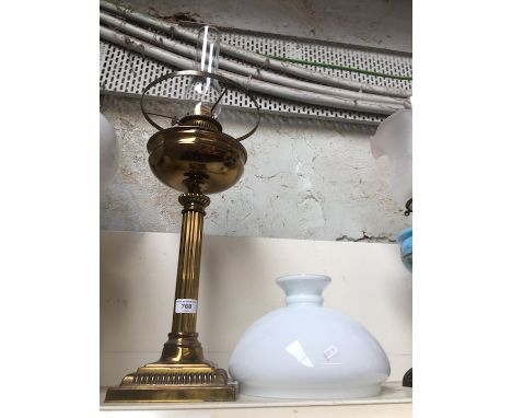 A brsss oil lamp with white bowl and glass flue 