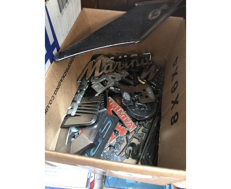A box of vintage car badges 