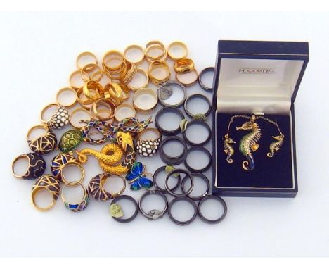 A mixed lot of gilt metal rings, including a group of enamel examples, and together with an enamel and paste set seahorse pen