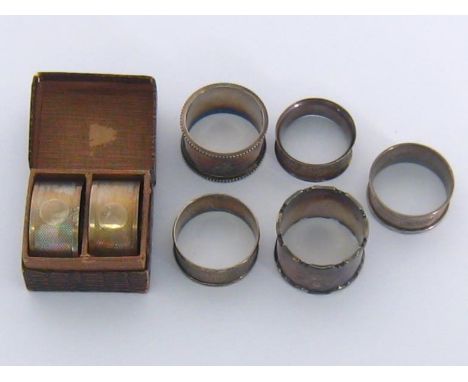 A pair of oval engine-turned napkin rings with vacant reserves, cased, by Crisford &amp; Norris, Birmingham, 1930; 3 other si