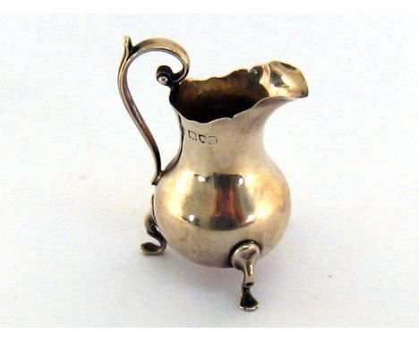 A small late Victorian silver cream jug of baluster form on three feet, by E. J. &amp; N. Haseler, London, 1899, 8.5 cm. high