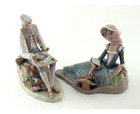 Two ceramic figures, one a lady reclining on the ground with a basket of flowers, the other a young man having finished paint