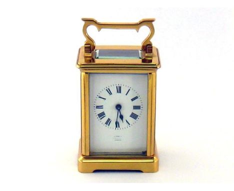 Asprey. A brass carriage clock with French movement and key, the white enamel dial with black Roman numerals and marked “Aspr