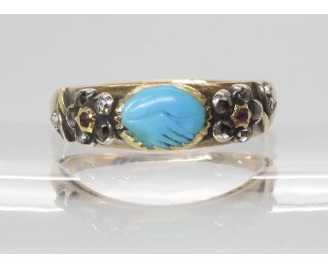 A MOURNING RING in yellow metal, set with diamond and ruby forget-me-not flowers and a turquoise carved with clasped hands. A