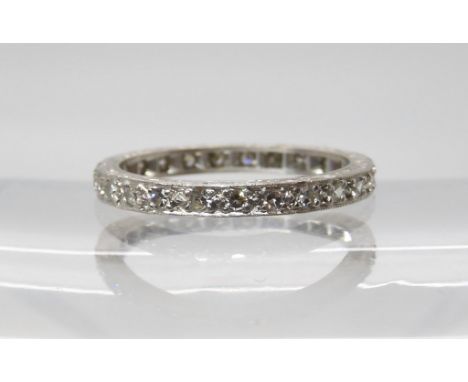 A SLIM DIAMOND FULL ETERNITY RING set with estimated approx 0.30cts of eight cut diamonds, made in un-hallmarked white metal,