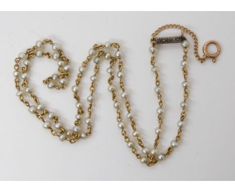 A STRING OF NATURAL PEARLS individually strung on yellow metal wire with rose cut diamond clasp. Each pearl is slightly diffe