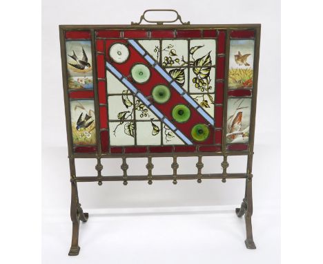 A VICTORIAN BRASS AND STAINED GLASS FIRE SCREEN with four hand painted inset panels depicting seasonal birds flanking central