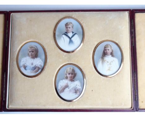 A FAMILY GROUP OF PAINTED OVAL PORTRAIT MINIATURES comprising three girls and one boy, 7 x 5.5cm, in original fitted case wit