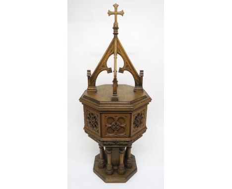 A PUGINESQUE OAK OCTAGONAL BAPTISMAL FONT with architectural style oak font cover concealing stone basin, carved reliefs to e