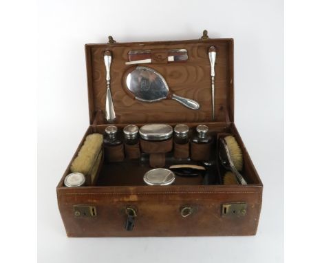 AN EDWARDIAN SILVER AND CUT GLASS LADIES DRESSING SET comprising vanity jars, clothes brushes, hair brushes, shoe horn, hand 